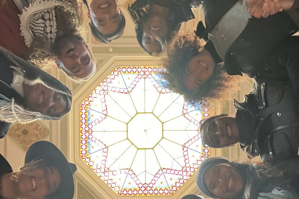 A group under a rotunda dome, photographed from the centre, everyone looking up.