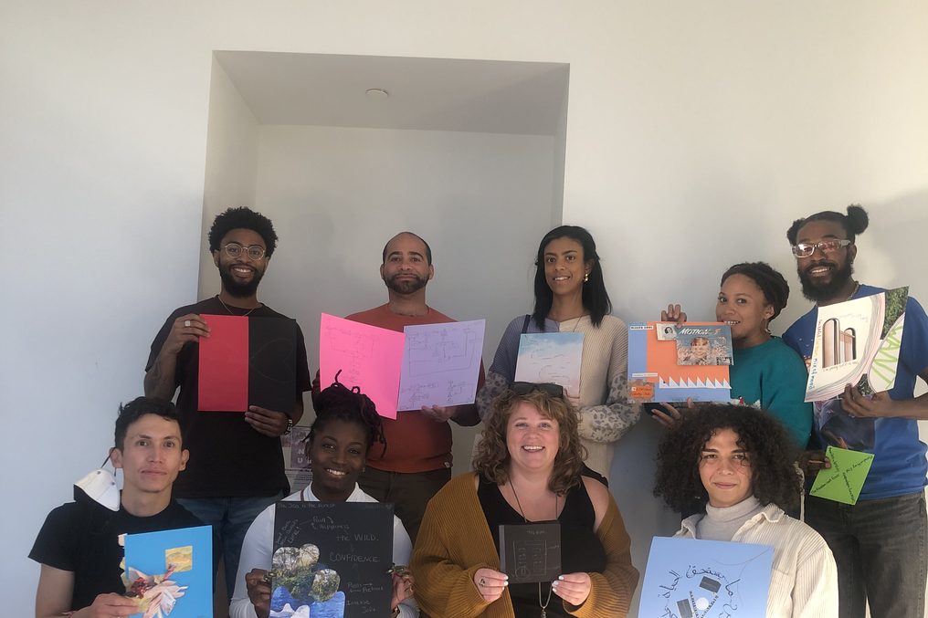Workshop participants holding up the work they made.