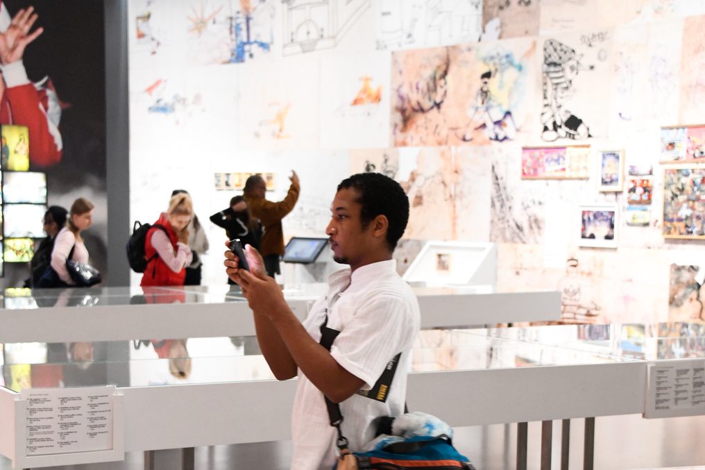 A visitor photographing a drawing wall.
