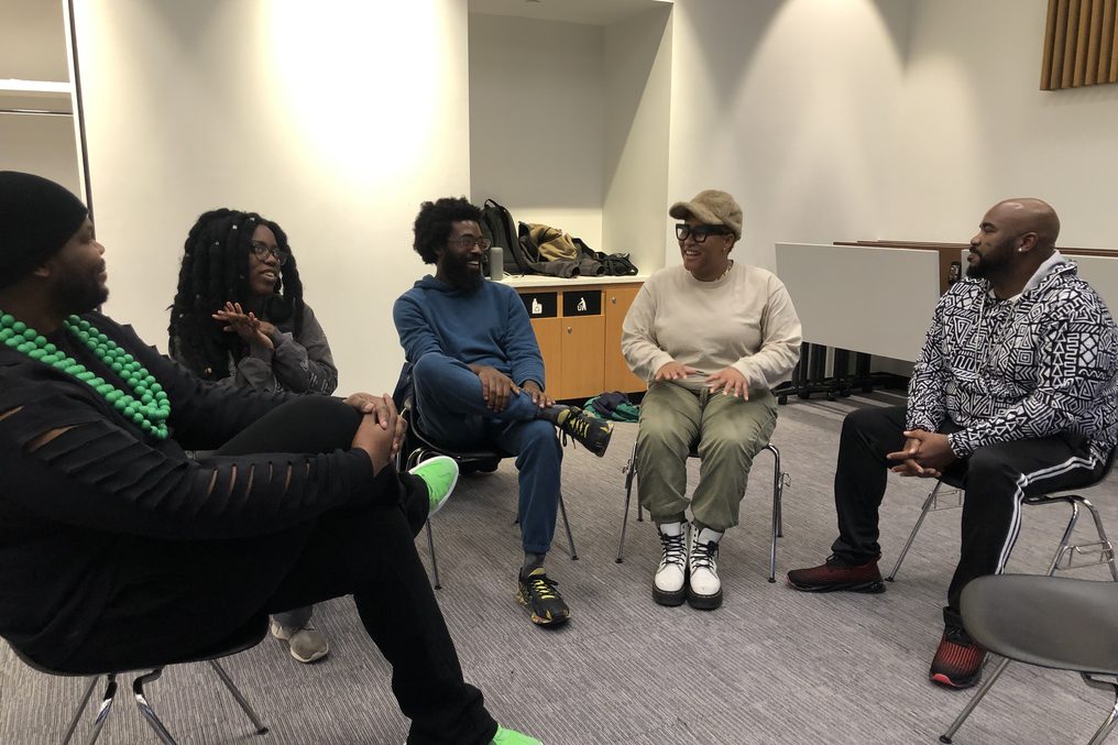 A circle of chairs mid-conversation, people laughing.