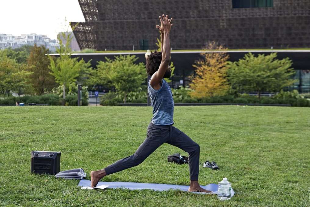 A warrior pose on the Mall, the National Museum of African American History and Culture behind.