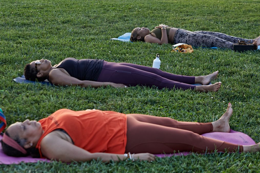 Rows of people in savasana on the National Mall lawn.